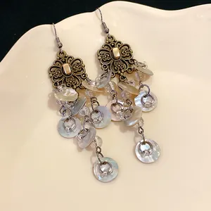 Close-up detail of vintage bohemian floral tassel earrings with iridescent shell drops