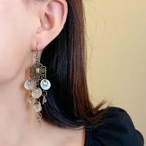 Close-up detail of Bohemian style vintage long drop earrings with white shell tassels