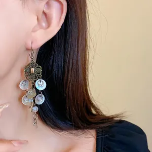 Close-up of Bohemian floral tassel earrings worn on an ear for a vintage look