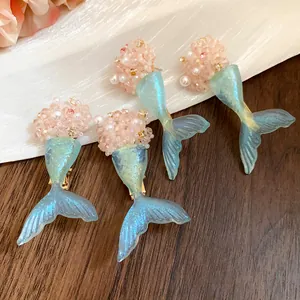 Detailansicht von verträumten Meerjungfrauenschwanz-Accessoires mit rosa Perlen und blauen Flossen