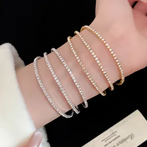 Elegant stacked rhinestone tennis bracelets in gold and silver tones displayed on a wrist.