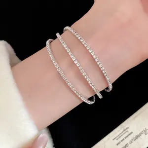 Close-up detail of a triple-layer minimalist silver rhinestone open bracelet on a wrist
