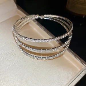 Detailed macro view of a silver triple-layer rhinestone-encrusted open bangle bracelet