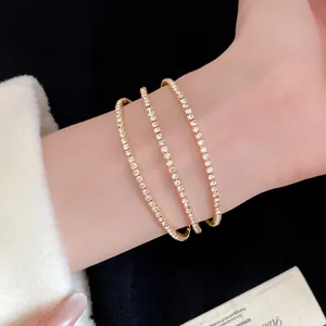 Detailed close-up of a elegant three-layer gold cuff bracelet with sparkling rhinestones