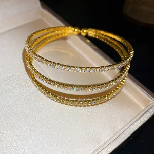 Close-up of a three-layer gold-plated bracelet with stones in a gift box