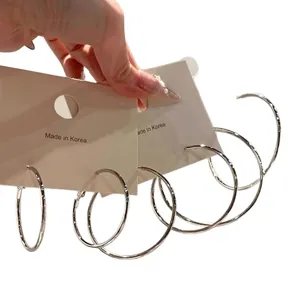 Stylish silver-plated metal hoop earrings set in various sizes held on display cards