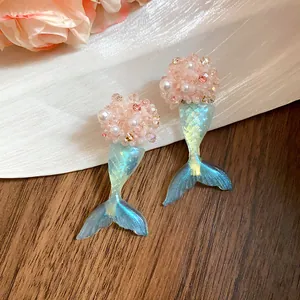 Detailansicht von rosa Perlen-Meerjungfrauenschwanz-Ohrringen mit blauem Harzverlauf