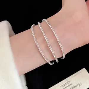 Close-up of a sparkling three-layer minimalist open bracelet worn on a woman's wrist