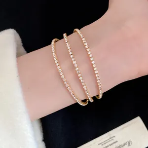 Elegant gold three-layer rhinestone open bangle bracelet shown on a wrist closeup detail