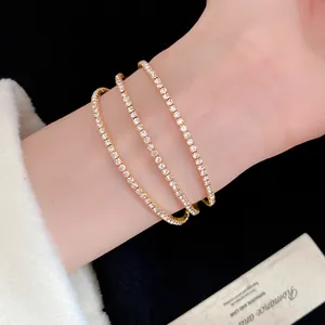 Elegant three-layer gold-tone bracelet set with shimmering crystals on a woman's wrist
