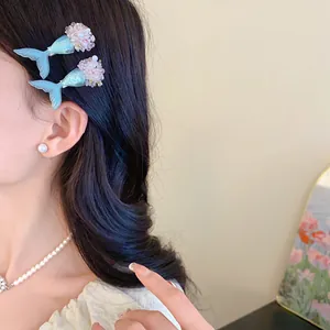 Nahaufnahme eines Models mit blauen Meerjungfrauenschwanz-Haarspangen und Perlensteckern