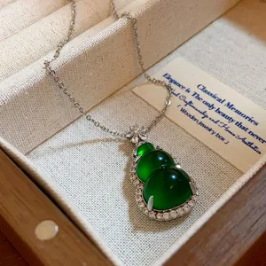 Detail view of a green resin gourd pendant necklace with sparkling zircon borders.