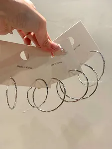 Close-up of silver metal hoop earrings in varying sizes on display cards