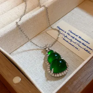 Close-up of green resin gourd pendant with zircon accents on silver chain