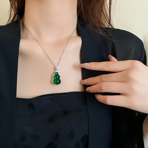 Detailed view of a Chinese style green resin Wu Lou pendant necklace on a neck.