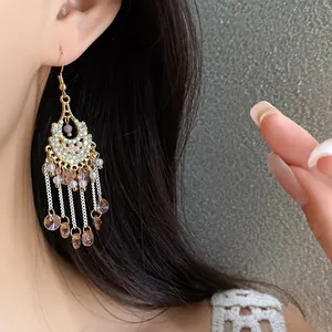 Detailed shot of Bohemian tassel earrings with rhinestones and pearls on an ear.