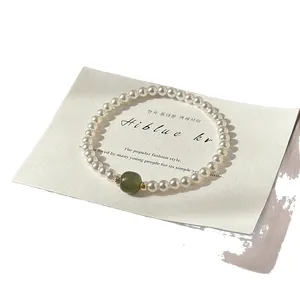 Bracelet en perles vintage français avec une pierre focale verte élégante sur carte blanche.