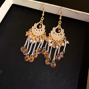 Close-up view of bohemian vintage tassel earrings featuring sparkling crystals and white pearls