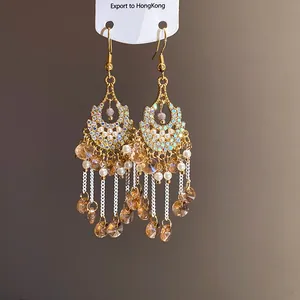 Detailed view of vintage Bohemian drop earrings with rhinestones, pearls and glass tassels