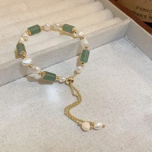 Vue détaillée d'un bracelet vintage en perles et jade vert dans un coffret à bijoux