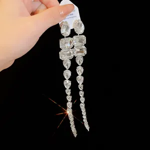 Dettaglio di orecchini a nappa lunga con cristalli a goccia d'acqua scintillanti.