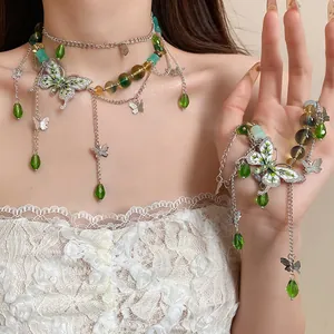 Dettaglio del set di gioielli a farfalla con perle di vetro verdi e strass scintillanti