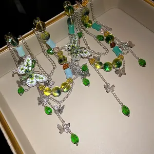 Dettaglio della collana di perline a farfalla con cristalli verdi e strass