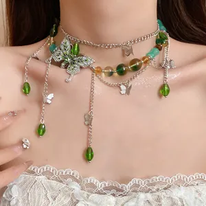 Vista dettagliata della collana a farfalla con perline di vetro verdi e pendenti in argento