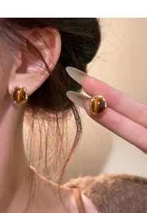Detailed view of vintage Maillard style brown resin stud earrings with gold plating
