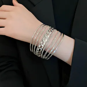 Vue détaillée de bracelets joncs argentés superposés avec motif géométrique ajouré