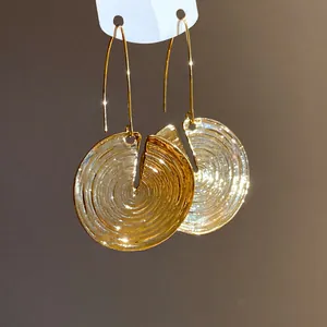 Nahaufnahme goldener runder Ohrhänger mit einem vintage konzentrischen Rillendesign