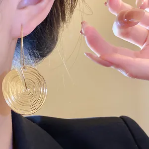 Detailansicht goldener runder Ohrringe mit Textur und minimalistischem Haken