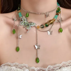 Dettaglio della collana a strati con perline di vetro verdi e pendenti a farfalla smaltati.