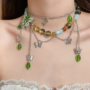 Dettaglio di una collana a farfalla a strati con perle di vetro verdi su un modello.