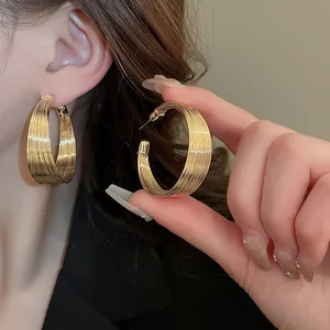 Detailed close-up view of elegant gold multi-layered hoop earrings worn by a model