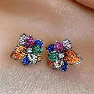 Detailed shot of exquisite multi-colored zircon flower earrings on satin background