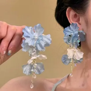 Detailed look at elegant blue fabric flower tassel earrings with pearls and crystals