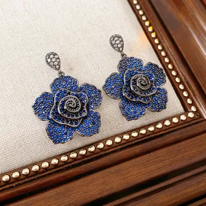 Detail macro view of vintage flower stud earrings with blue and clear zircon stones