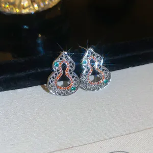 Detailed macro view of sparkling hulu shaped silver earrings set with colorful zircons