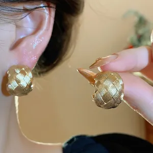 Elegantes pendientes de botón en C dorados con un diseño de textura tejida único
