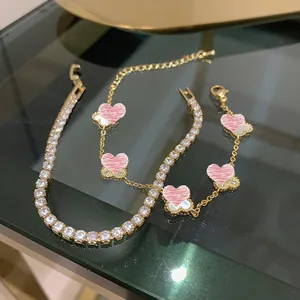 Dettaglio di bracciali placcati oro 14K con zirconi e madreperla rosa a cuore