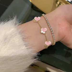 Primo piano di un braccialetto placcato oro 14K con fiori di madreperla e zirconi