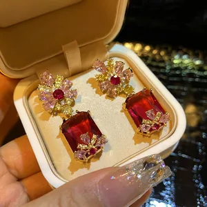 Close-up of vintage style floral earrings with large red rectangular zircon drops.