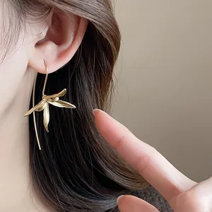 Dettaglio ravvicinato degli orecchini a fiore iris vintage in oro indossati dalla modella.