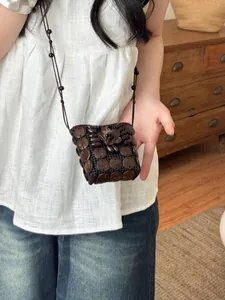 Detail view of a bohemian retro mini bag made from dark coconut shells and beads.