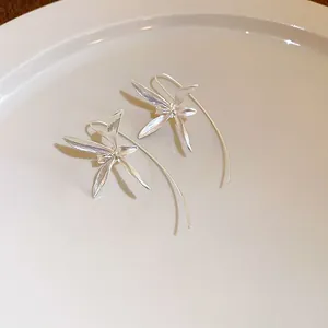 Dettaglio di eleganti orecchini vintage in argento a forma di iris con ganci curvi
