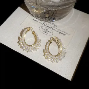 Macro detail of vintage gold-toned earrings featuring double rows of pearls and crystals