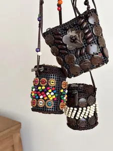 Detailed view of three bohemian handmade coconut shell neck pouches with colorful beads