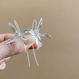 Dettaglio macro di orecchini a forma di iris in argento retrò con elegante gancio lungo