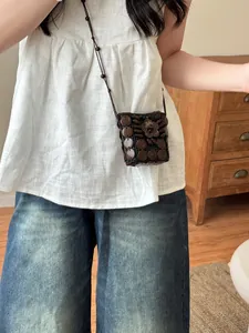 Handcrafted Bohemian coconut shell coin purse necklace worn on white linen sleeveless top